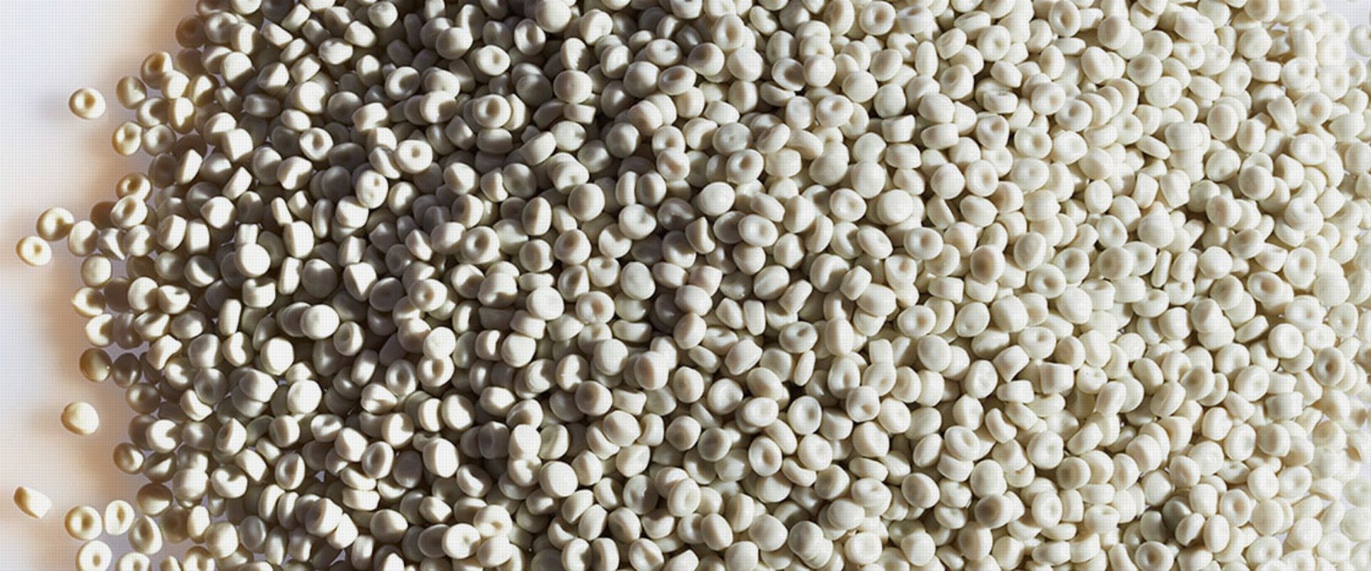 Ein Haufen weißer Kunststoffgranulate, die für die Herstellung oder das Recycling von Kunststoffprodukten verwendet werden.