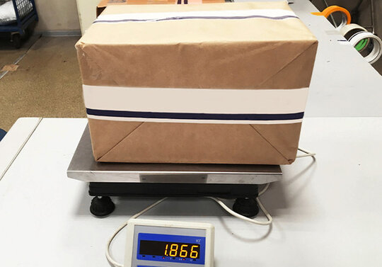 Ein Paket auf einer digitalen Waage, die ein Gewicht von 1,866 Kilogramm anzeigt.